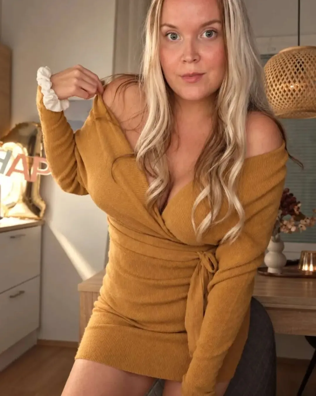 @laurakoo_lifestyle kamelinruskeassa olkapäät paljastavassa wrap-look-neulemekossa, jossa on vyö